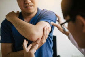 Physical therapists are checking patients elbows at the clinic office room.